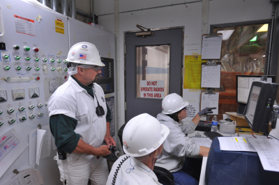 Joe Woodard works with his staff members at the Arkansas City plant
